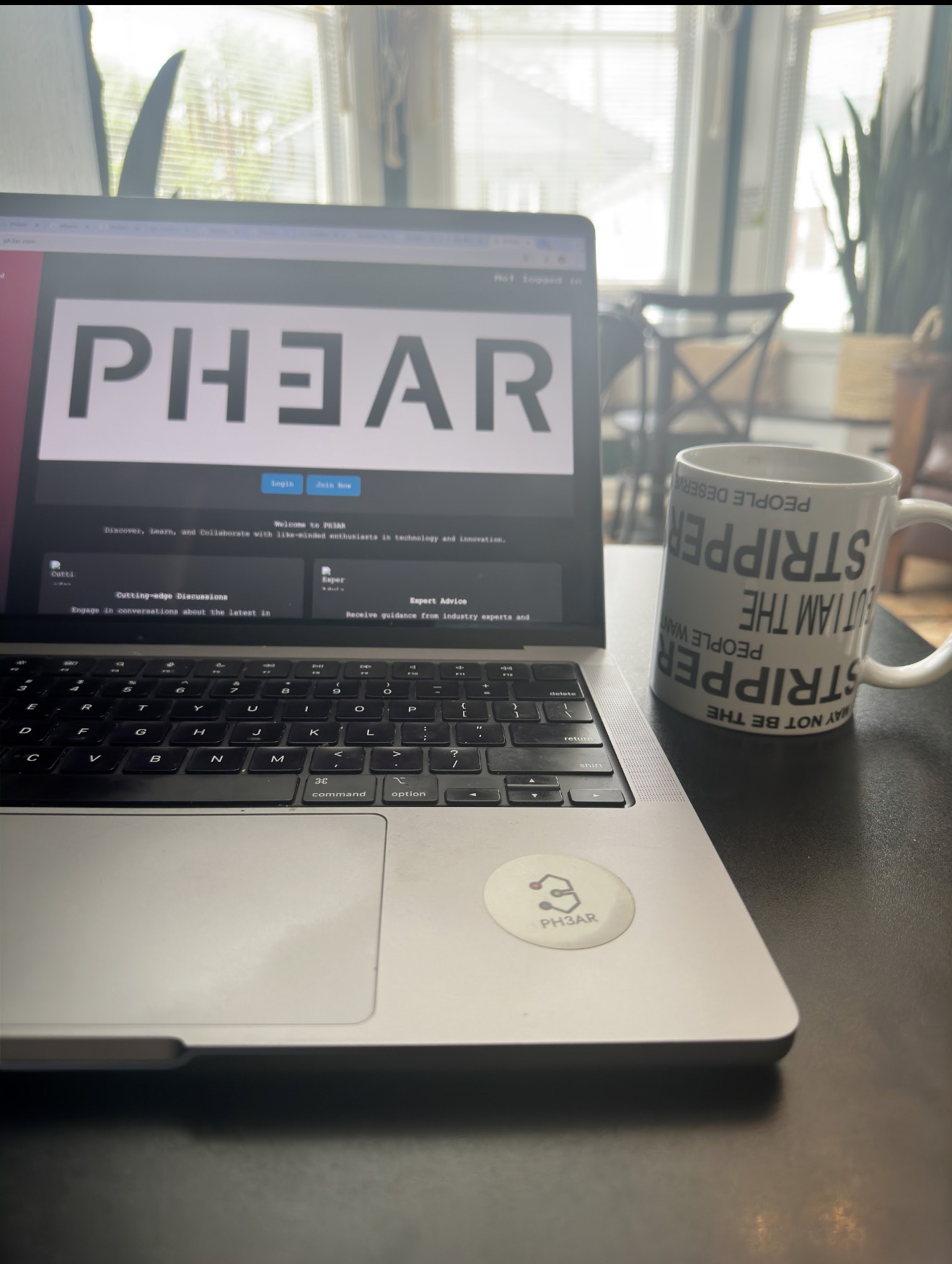 Stripper Mug next to laptop showing PH3AR website